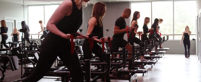 Group fitness class using resistance bands on Megaformer machines
