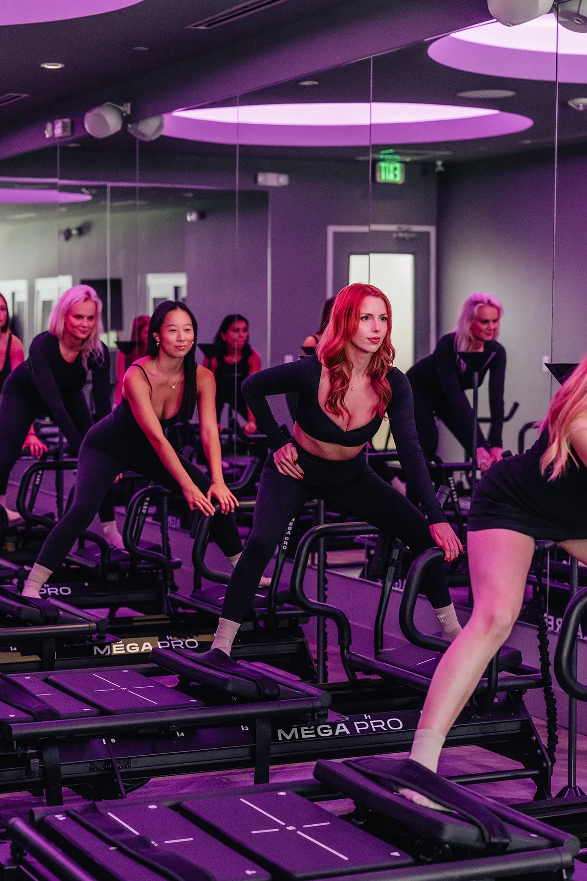 group-lagree-training-lunge-exercise-tight-dallas Lagree class performing lunges on Megaformer machines at TIGHT Dallas.
