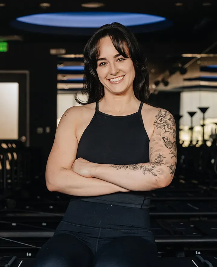 fitness-instructor-danielle-wight-smiling-with-arms-crossed-in-modern-studio.tight-dallas. Fitness instructor Danielle Wight smiling with arms crossed in a studio.