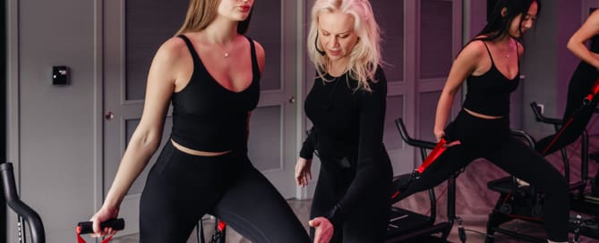 Lagree-certified instructor guiding a beginner through a Megaformer lunge during a first-time class at TIGHT Dallas.