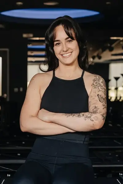 Fitness instructor Danielle Wight smiling with arms crossed in a studio.