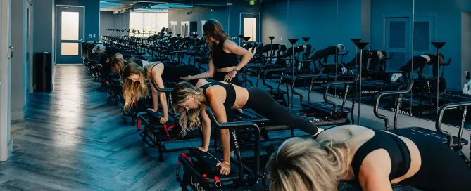 Instructor guiding a Lagree class on Megaformer machines at TIGHT Dallas studio