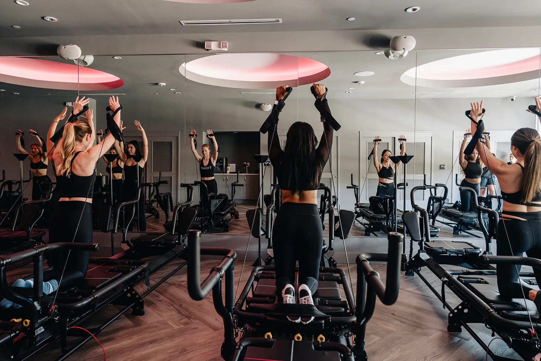 Woman focused on full-body workout using a Megaformer machine at Tight Dallas fitness studio